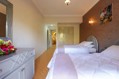 a hotel room with two beds and a bathroom at In Club Palmeraie Resorts in Marrakech