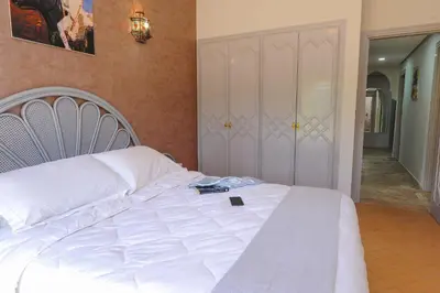 a bedroom with a white bed with a book on it at In Club Palmeraie Resorts in Marrakech