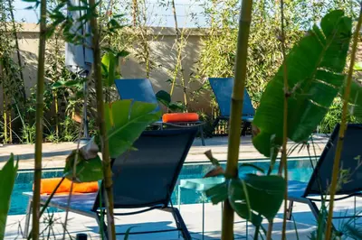 a group of chairs and a table next to a pool at Sirayane Boutique Hotel & Spa Marrakech in Marrakech
