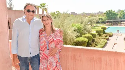 a man and a woman standing next to a wall at Les Jardins De Zyriab in Aït Hamid