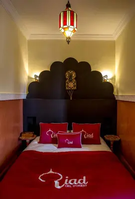 a bedroom with a red bed with a red blanket at Riad Ciel d'Orient in Marrakech