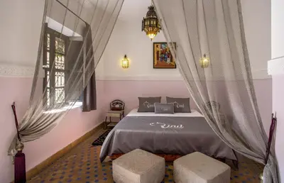 a bedroom with a bed with two stools at Riad Ciel d'Orient in Marrakech