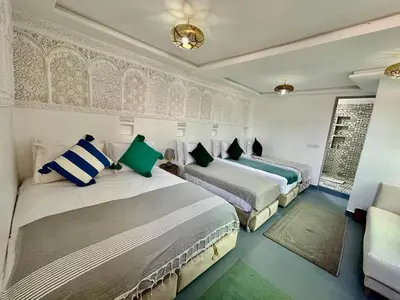 a bedroom with two beds and a couch at Riad Green Vines in Marrakech