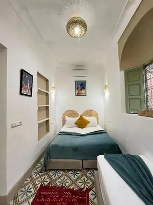 a bedroom with a bed with a green comforter at Riad Green Vines in Marrakech