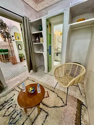 a living room with a table and a chair at Riad Green Vines in Marrakech