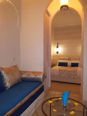 a bedroom with a bed and a table in a room at Dar Andamaure in Marrakech