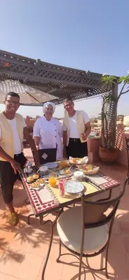 a group of people standing around a table with food at Dar Andamaure in Marrakech