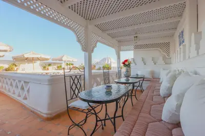 a living room with a couch and tables on a balcony at Riad Palais Des Princesses & Spa in Marrakech