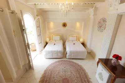 a bedroom with two beds and a rug at Riad Palais Des Princesses & Spa in Marrakech