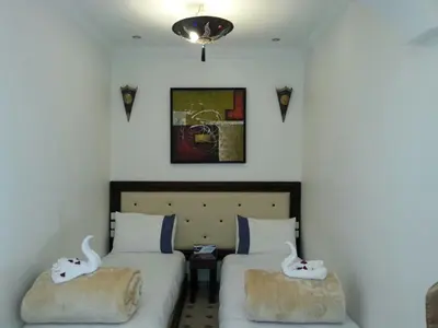 a bedroom with two beds with towels on them at Les Rêves De Marrakech in Marrakech