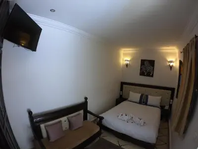 a small bedroom with a bed and a television at Les Rêves De Marrakech in Marrakech