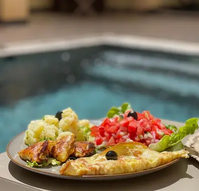 a plate of food with meat and vegetables on a table at Riad Jardin Des Rêves in Marrakech