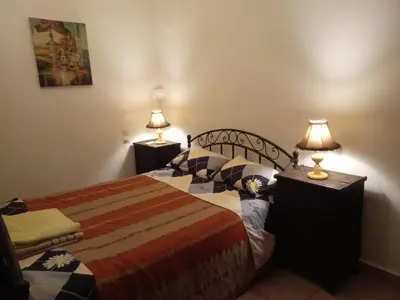 a bedroom with a bed and two night stands with lamps at Riad Tifor in Marrakech