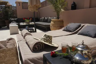 a patio with a bed with a hat on it at Riad Utopia Suites And Spa in Marrakech