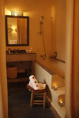 a bathroom with a sink and a mirror and a stool at Riad Utopia Suites And Spa in Marrakech