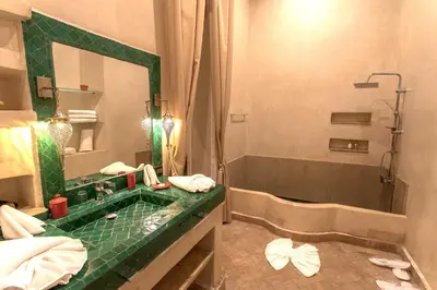 a bathroom with a green sink and a shower at Le Medina Privilège Riad & Spa in Marrakech