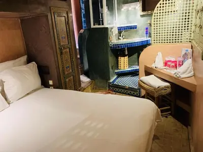 a small room with a bed and a sink at Riad Moullaoud in Marrakech