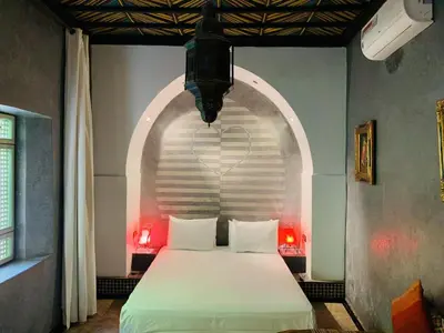 a bedroom with a bed with an arched doorway at Riad Moullaoud in Marrakech