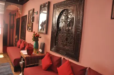 a living room with red couches and a picture on the wall at Riad des Etoiles in Marrakech