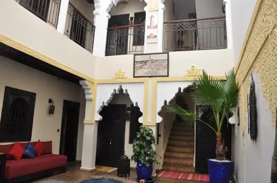 a living room with stairs and a red couch at Riad des Etoiles in Marrakech