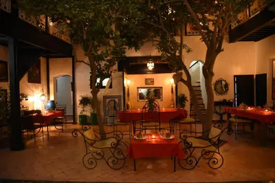 a restaurant with tables and chairs and a tree at Riad Du Petit Prince in Marrakech