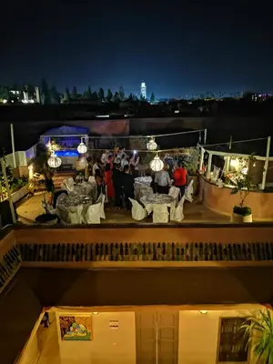 a group of people standing on a rooftop at night at Riad Vendôme & Spa in Marrakech