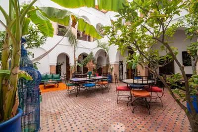 a courtyard with tables and chairs and plants at Riad Le Jardin de Lea, Suites & Spa in Marrakech