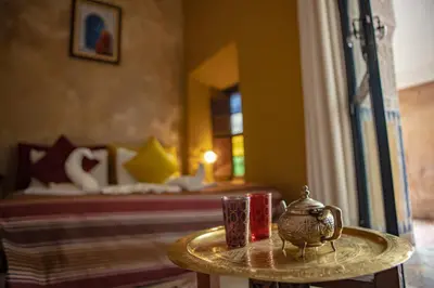 a table with two candles and a bed in a room at Riad Le Jardin de Lea, Suites & Spa in Marrakech