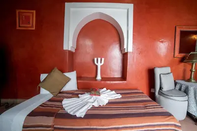 a bedroom with a bed with orange walls at Riad Le Jardin de Lea, Suites & Spa in Marrakech