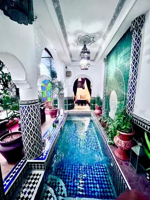 a large swimming pool in a room with at Riad Assalam in Marrakech