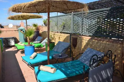 a group of chairs and umbrellas on a patio at Riad Assalam in Marrakech