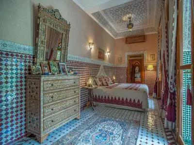 a bedroom with a bed and a dresser and a mirror at Riad & Spa Laurence Olivier in Marrakech