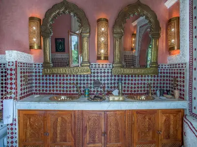 a bathroom with two sinks and two mirrors at Riad & Spa Laurence Olivier in Marrakech