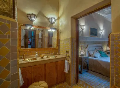 a bathroom with two sinks and a bed at Riad & Spa Laurence Olivier in Marrakech