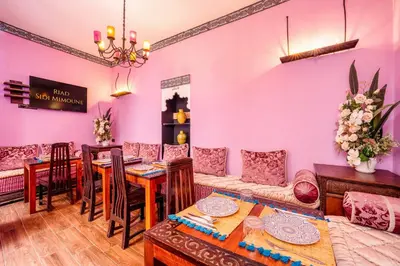 a living room with pink walls and a table and chairs at Riad Sidi Mimoune & Spa in Marrakech