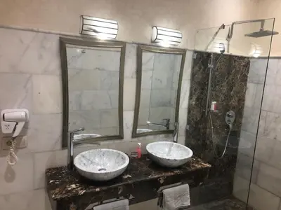 a bathroom with two sinks and a shower at Riad Nesma Suites & Spa in Marrakech