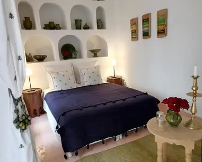 a bedroom with a bed and a table with flowers at Riad Dar Nouba in Marrakech