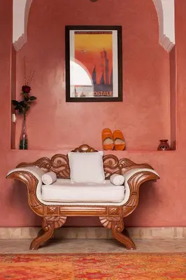 a couch sitting in a room with a red wall at Dar Sohane in Marrakech