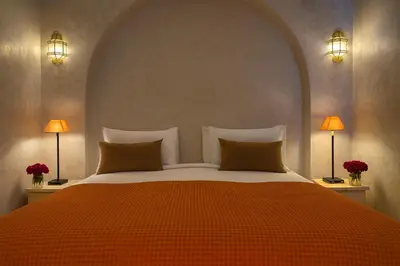a bedroom with a large bed with two lamps at Riad Dar More in Marrakech