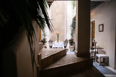 a hallway with a table and chairs in a building at Riad Dar More in Marrakech