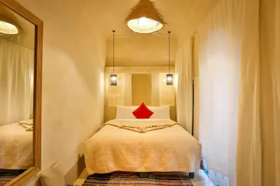 a bedroom with a bed with a red pillow on it at Hotel & Spa Dar Baraka & Karam in Marrakech