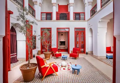 a living room with red chairs and a table at Hotel & Spa Dar Baraka & Karam in Marrakech
