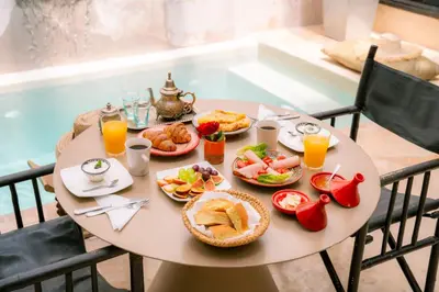 a table with plates of food and drinks on it at Riad Dar Massai in Marrakech