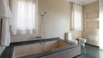 a bathroom with a bath tub and a toilet at Palais Ambrine in Marrakech