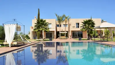 a large swimming pool in front of a building at Palais Ambrine in Marrakech