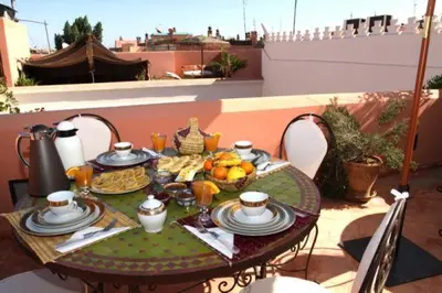 a table with a plate of food on a patio at Riad Cannelle in Marrakech