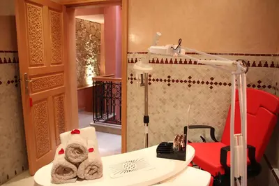 a room with a chair and a table and a lamp at Riad Léna & Spa in Marrakech
