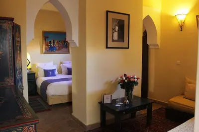 a hotel room with a bed and a table with flowers at Riad Léna & Spa in Marrakech