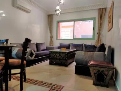 a living room with a couch and a table at Ritaj Apartement in Marrakech