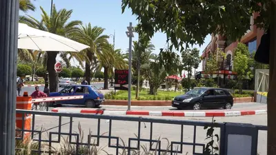 two cars are parked on a street next to a road at Ritaj Apartement in Marrakech